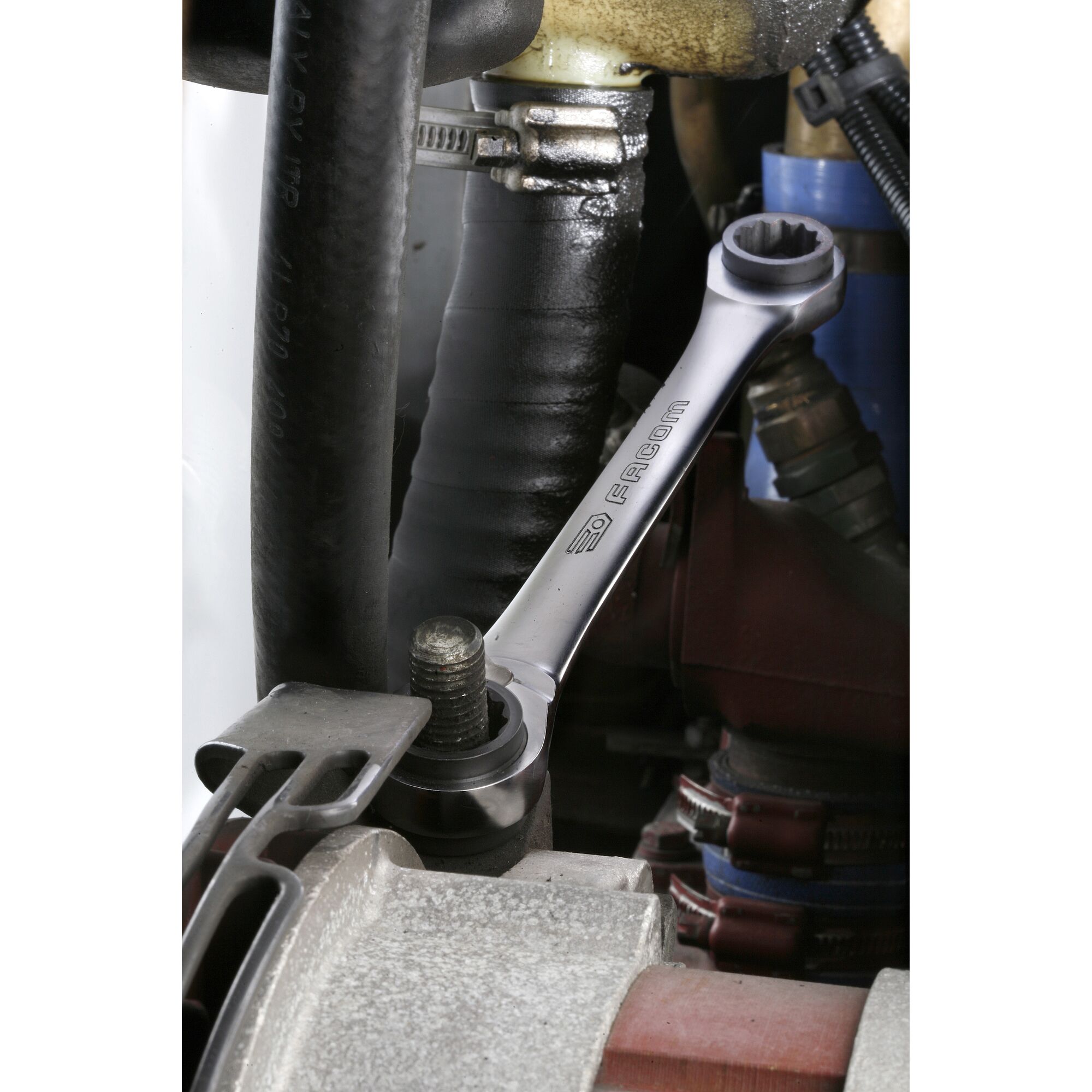 Photo of Facom 64C_J2PB ratcheting combination wrench tightening a bolt in an engine compartment.